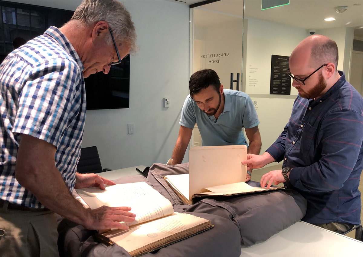 Professor David Kertzer and other scholars standing and inspecting documents, featured image for the digital publication Nicholas Brown and the Roman Revolution